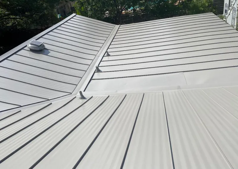 Solar attic fan installed on a metal roof for Roof Ventilation in West Loch Estate